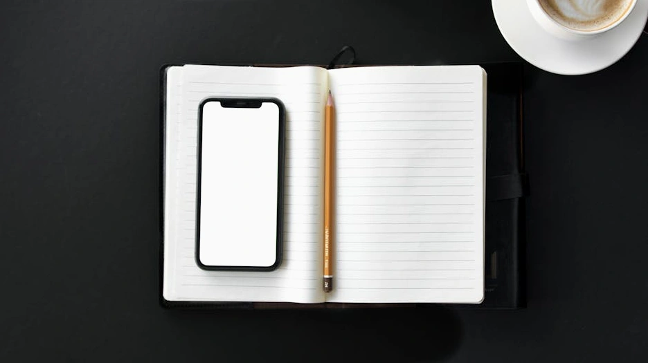 Osoba pracująca przy biurku, przeglądająca projekty na ekranie komputera.